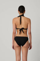 Black bikini with halter top and tie sides on a plain background