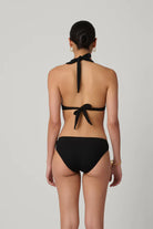 Black bikini with halter top and tie sides on a plain background