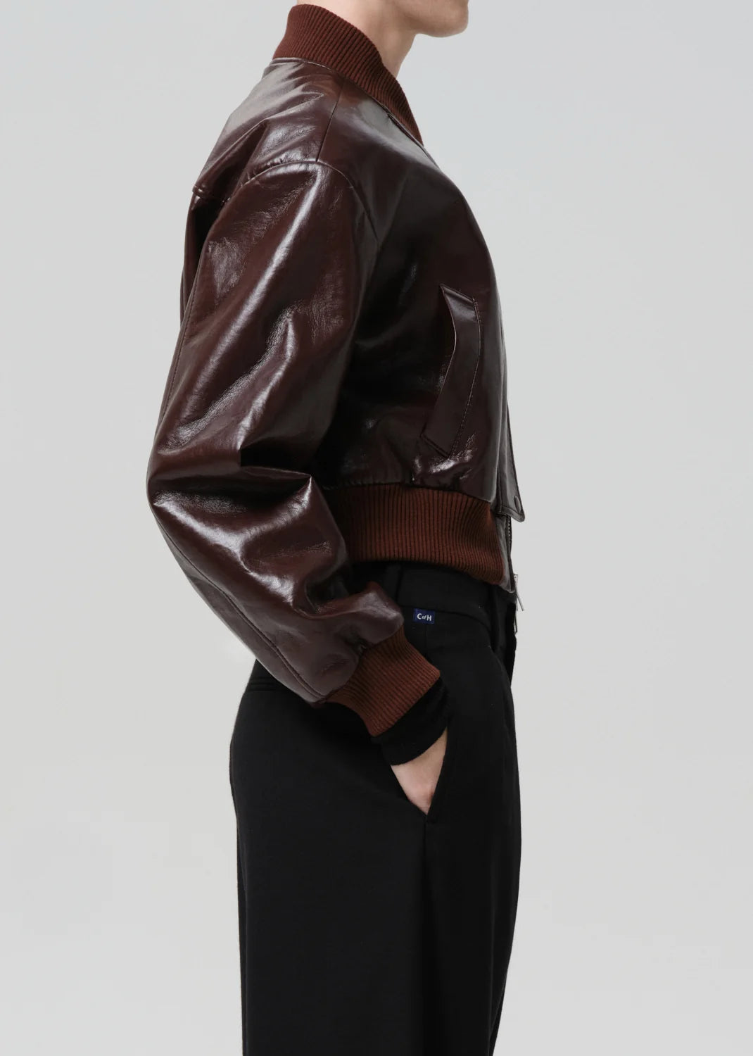 Brown leather jacket worn by a person on a light gray background