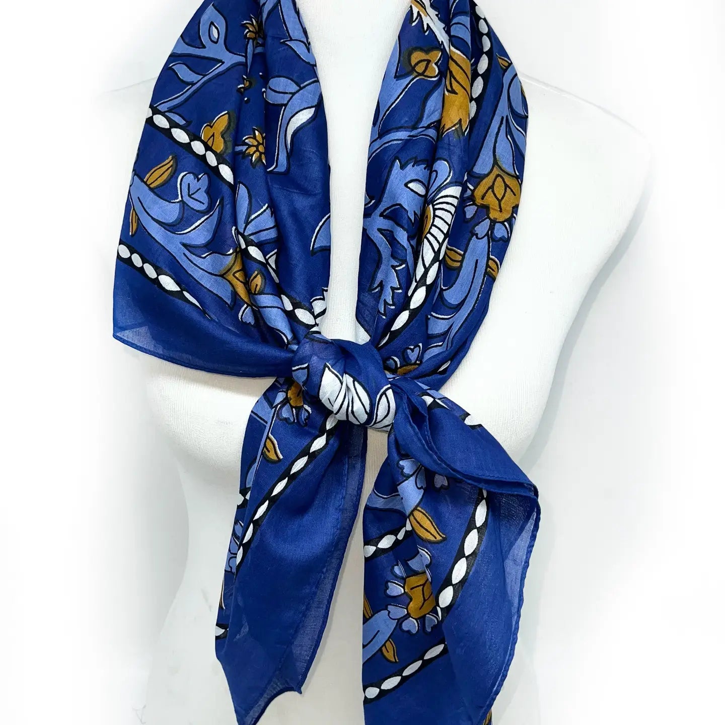 Blue floral patterned scarf tied in a knot on a white background