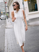 Woman in a white dress walking on a city street
