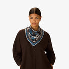 Woman wearing a patterned scarf on a white background