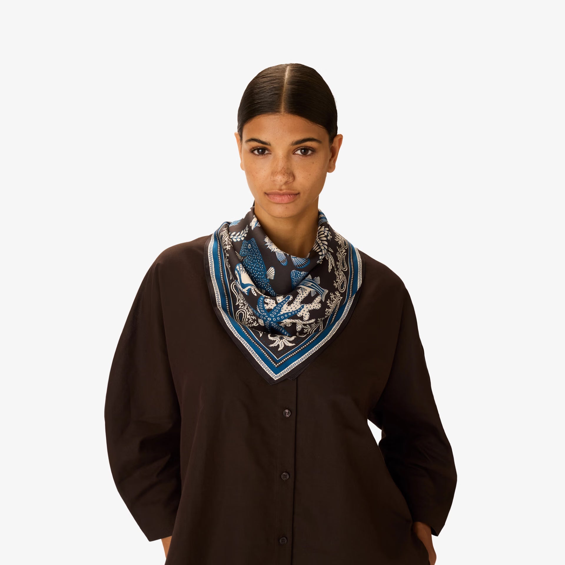 Woman wearing a patterned scarf on a white background