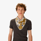 Man wearing a patterned scarf around his neck against a white background