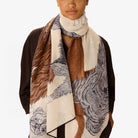 Person wearing a patterned scarf with brown, beige, and black design on a white background