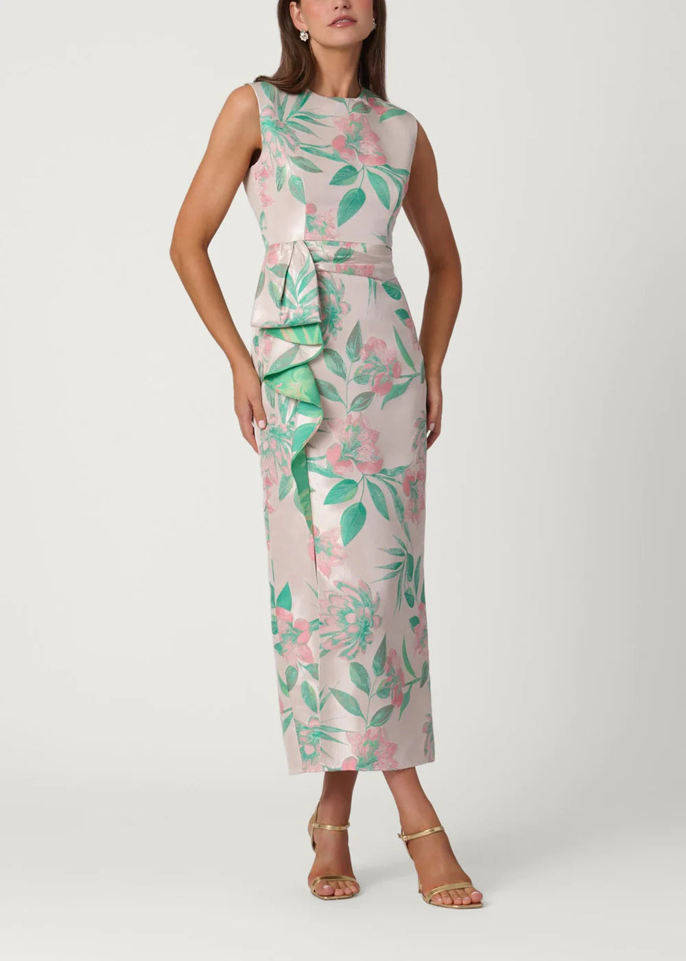 Woman wearing a floral dress with green and pink leaves on a white background