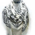 White scarf with black paisley patterns draped over a mannequin on a white background