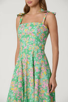 Green floral dress with pink and yellow flowers on a white background