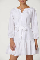 White dress with long sleeves and a tie waist on a plain background