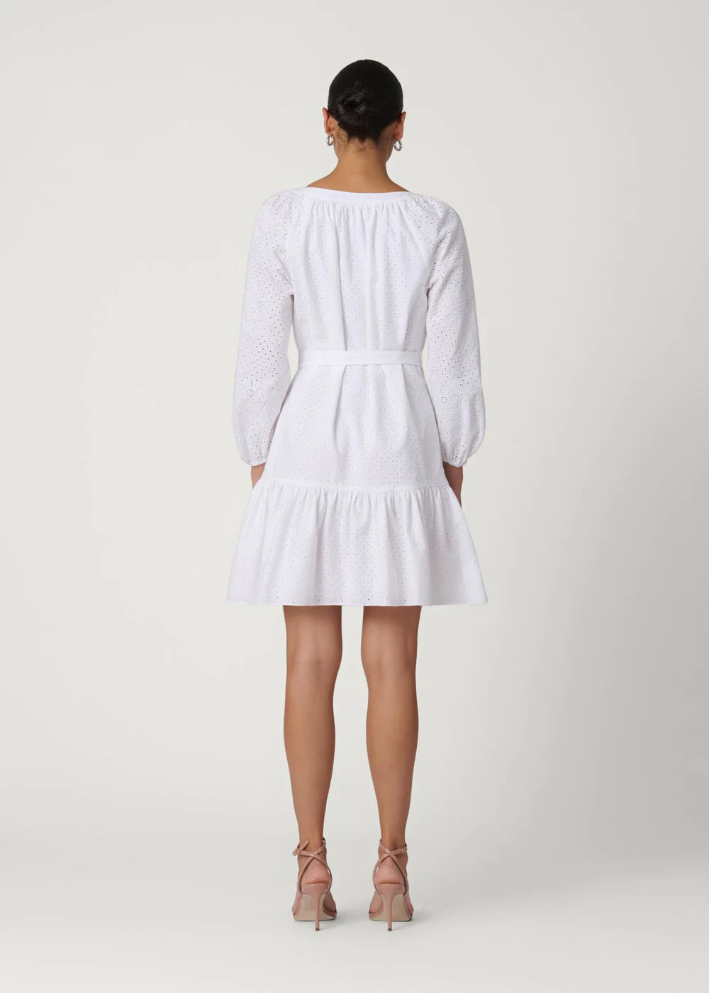 Woman wearing a white dress on a plain background