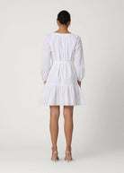 Woman wearing a white dress on a plain background