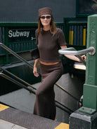Woman in brown outfit exiting a subway station