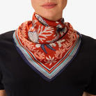 Person wearing a red patterned scarf on a white background