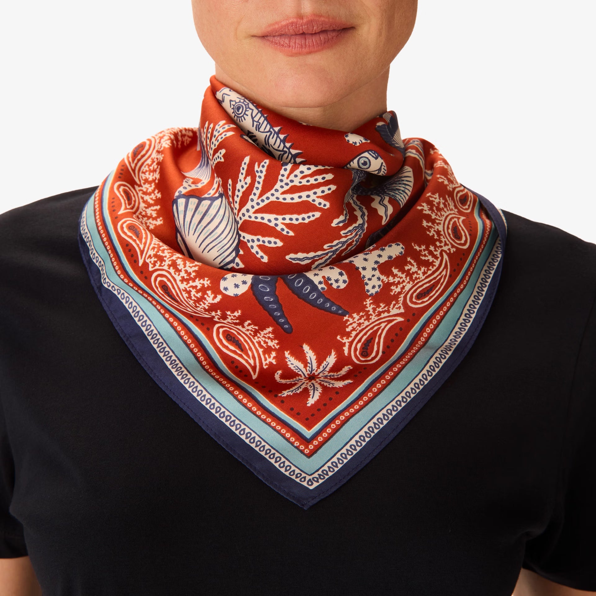 Person wearing a red patterned scarf on a white background