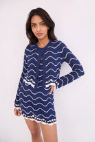Woman wearing a blue and white patterned dress on a white background