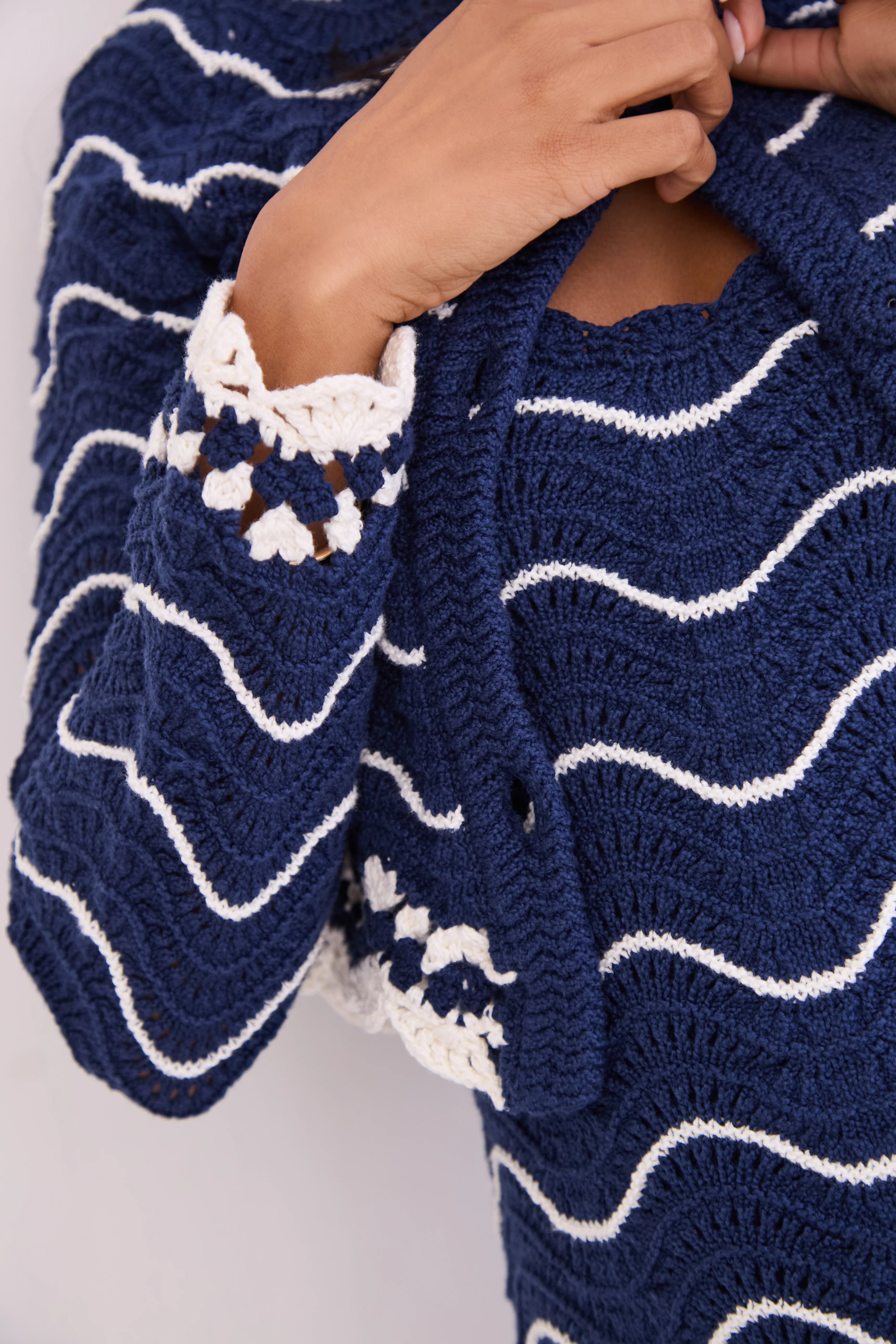 Navy blue and white striped knitted cardigan with a close-up of the pattern.