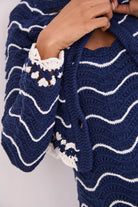 Navy blue and white striped knitted cardigan with a close-up of the pattern.