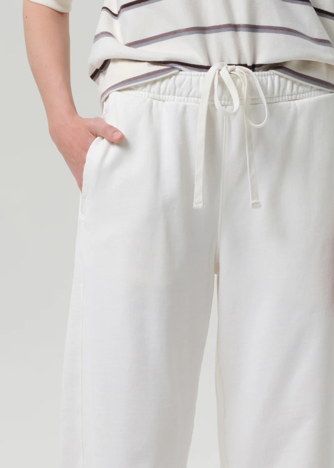 White pants with a drawstring waist on a plain background