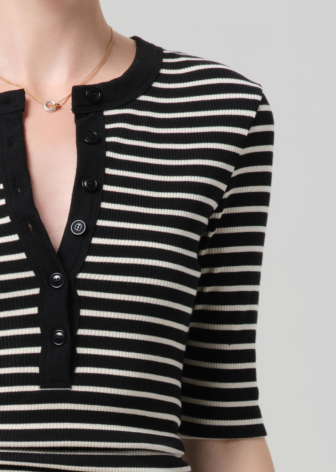 Black and white striped shirt with buttons on a neutral background