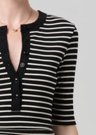 Black and white striped shirt with buttons on a neutral background