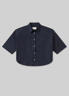 Navy blue short-sleeve shirt on a light gray background