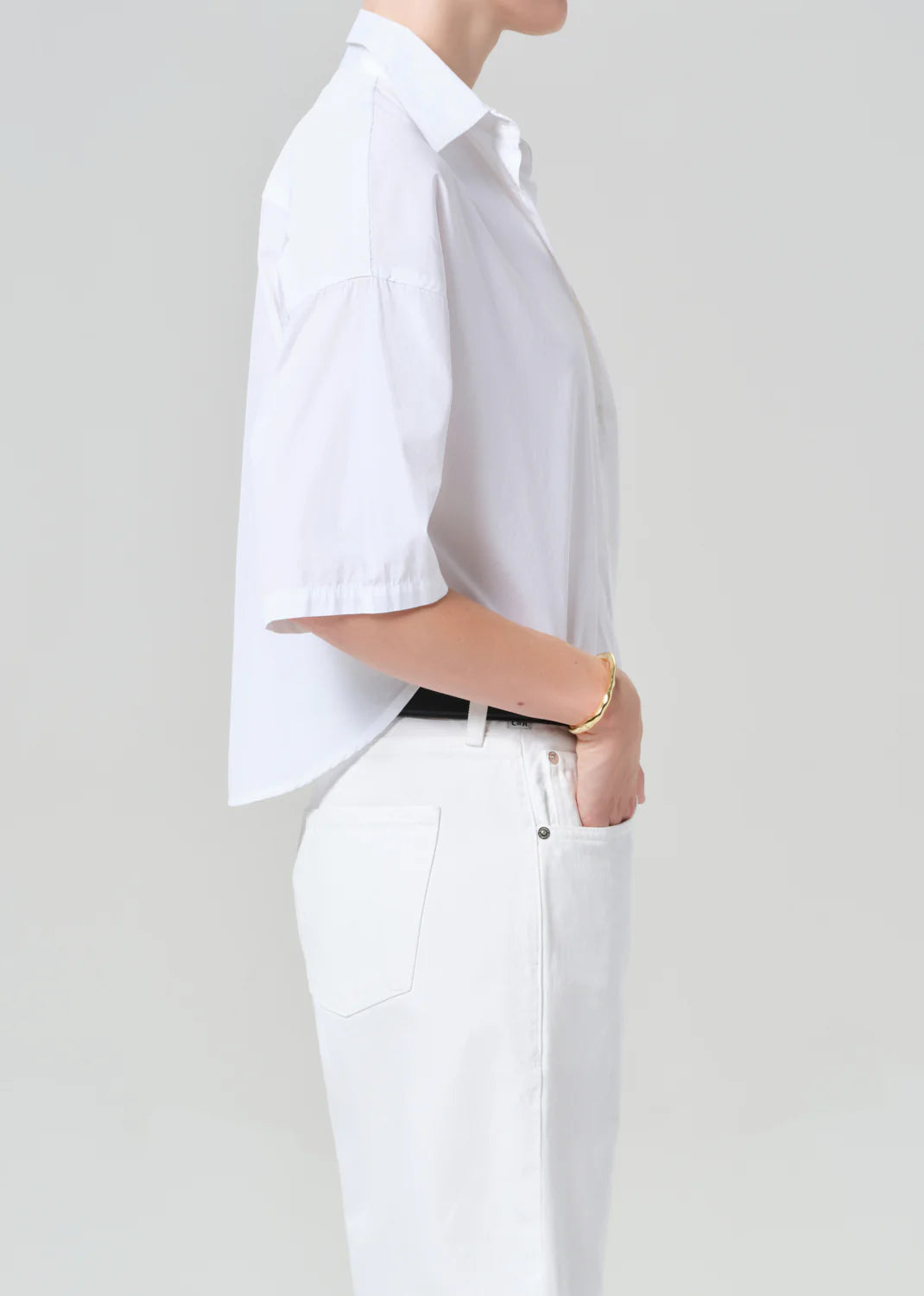 Person wearing a white shirt and pants on a plain background