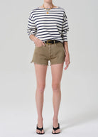 Person wearing a striped shirt and beige shorts on a white background