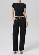 Person wearing a black outfit with a belt on a white background