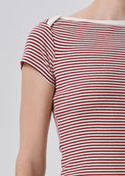 Close-up of a person wearing a short-sleeve ribbed top with horizontal red and off-white stripes, cropped from the neck to the upper torso against a light gray background.