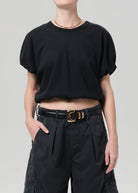 Front side view of a model wearing a black top and dark gray shorts on a white background