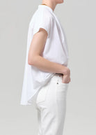 Person wearing a white t-shirt and pants on a plain background