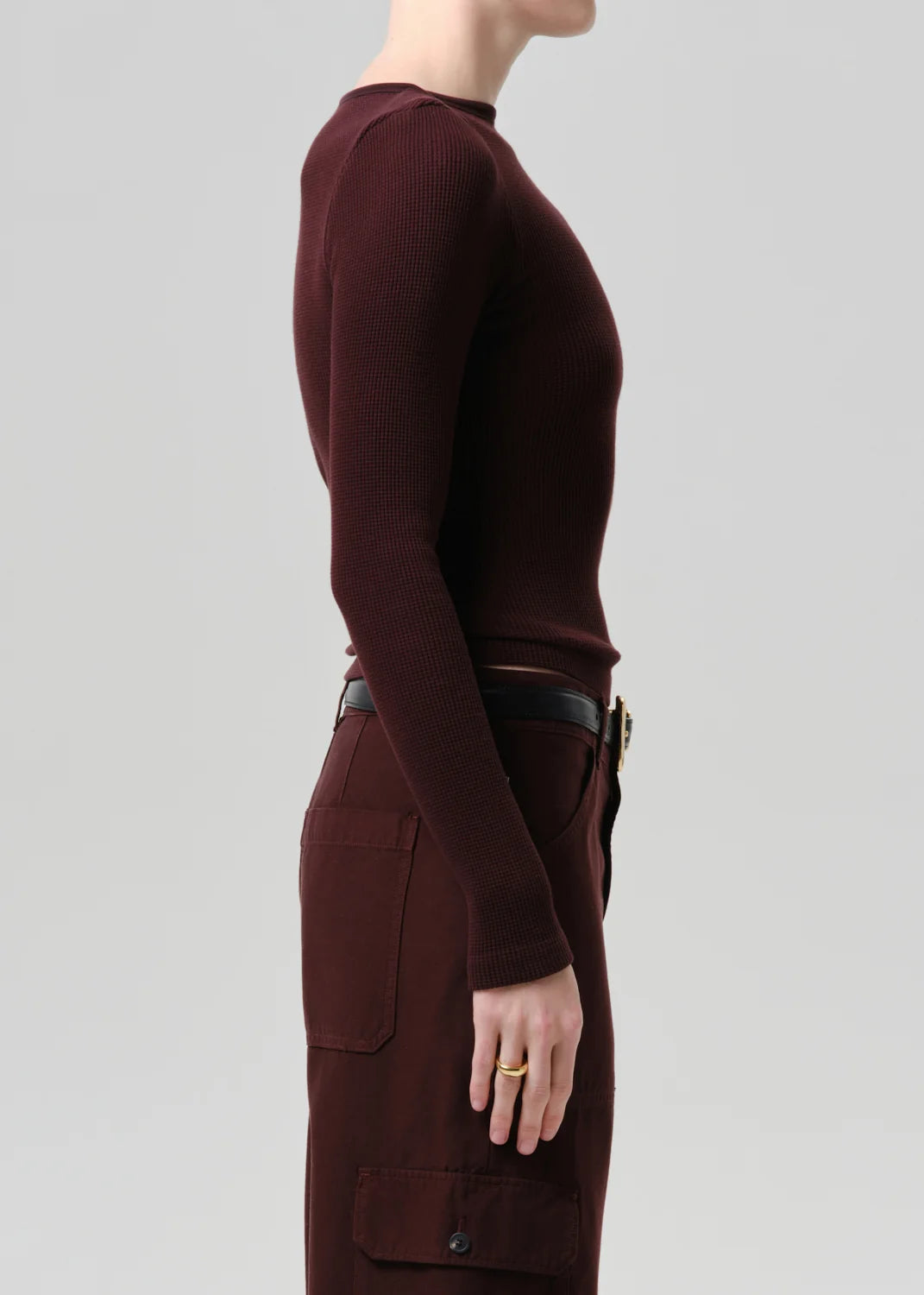 Person wearing a maroon long-sleeve top and pants on a light gray background
