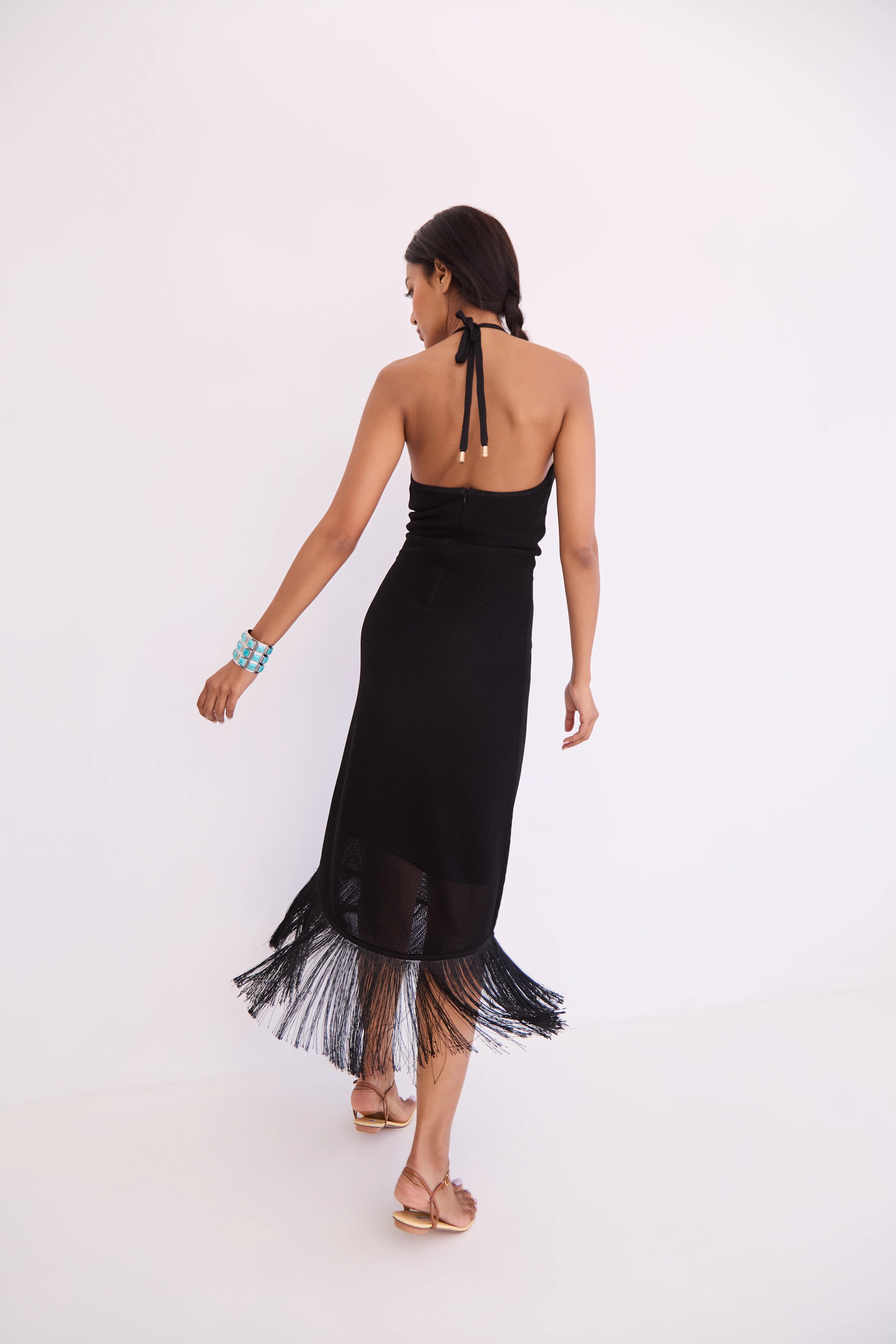 Woman wearing a black dress with sheer overlay on a white background