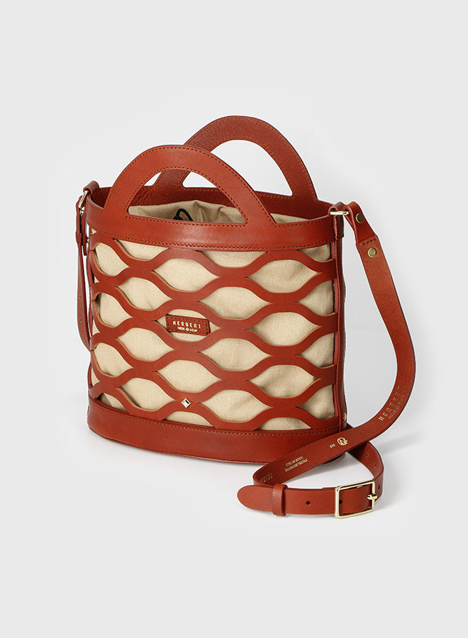 Brown leather handbag with beige mesh design on a light gray background