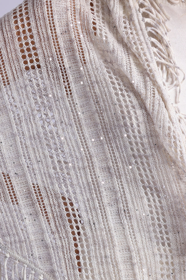 Close-up of a textured fabric with intricate patterns and fringes.