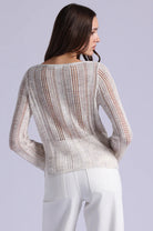Woman wearing a patterned sweater on a plain background