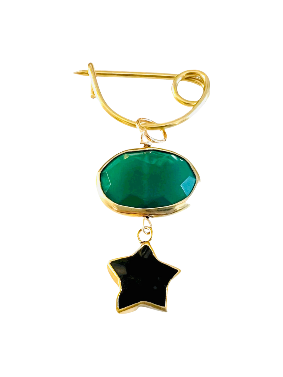 Gold brooch with green and black stone on a white background
