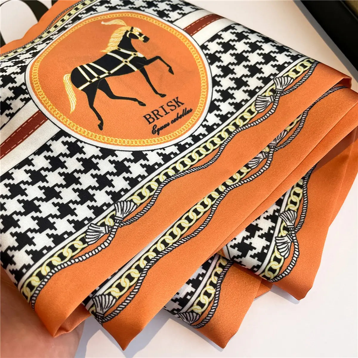 Patterned fabric with a horse logo and 'BRISK' branding on an orange background