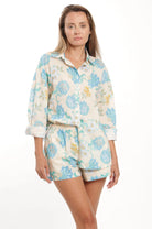 Woman wearing a floral pajama set on a white background