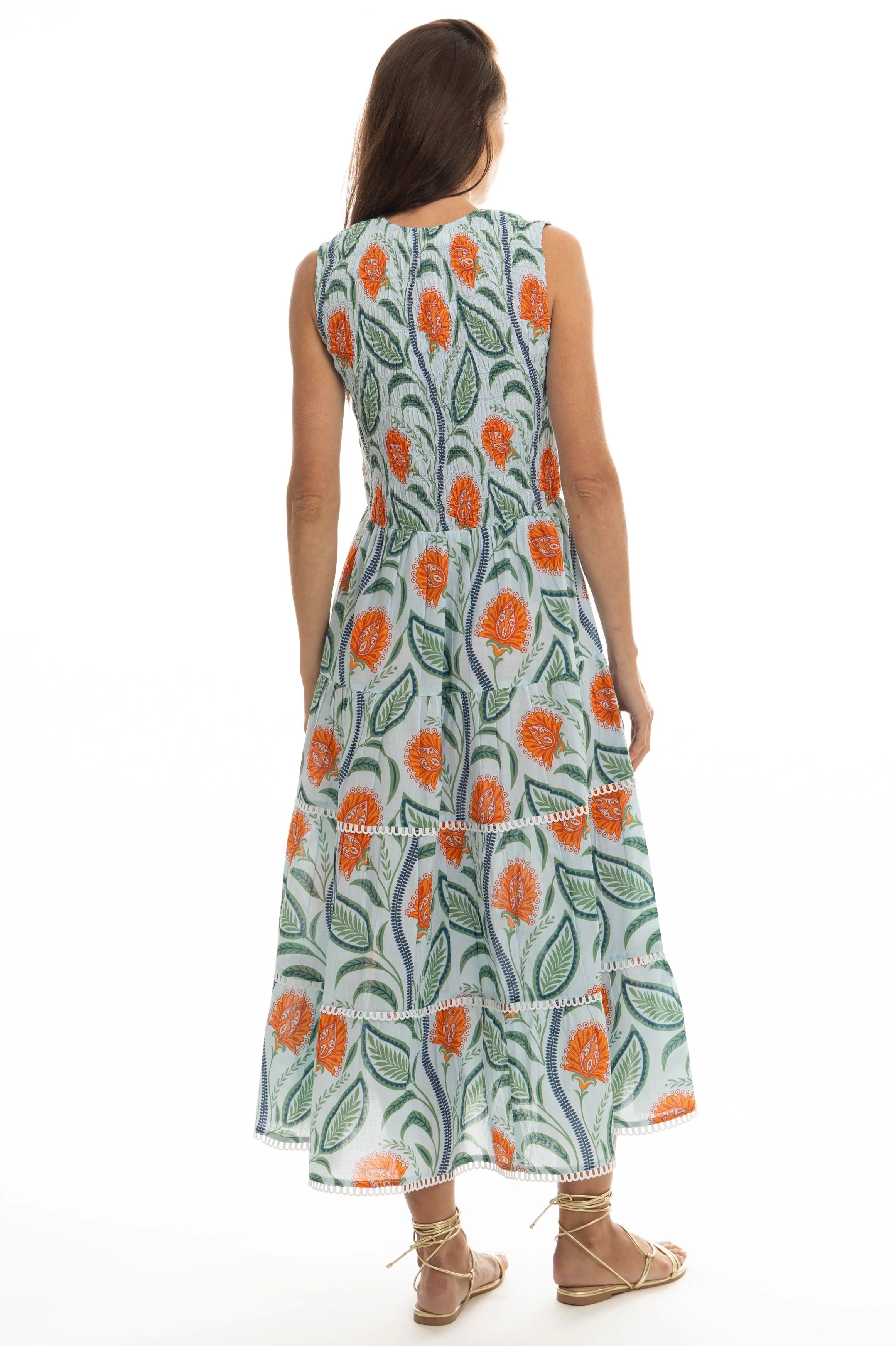 Woman wearing a sleeveless floral dress on a white background