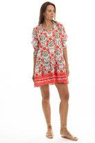 Woman wearing a colorful dress with a floral pattern on a white background