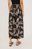 Person wearing a patterned skirt on a plain background