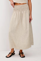 Beige skirt worn by a person on a white background