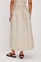 Beige skirt worn by a person on a white background