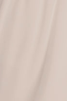A close-up of draped satin fabric in a light champagne beige color, showing soft folds and a subtle sheen.