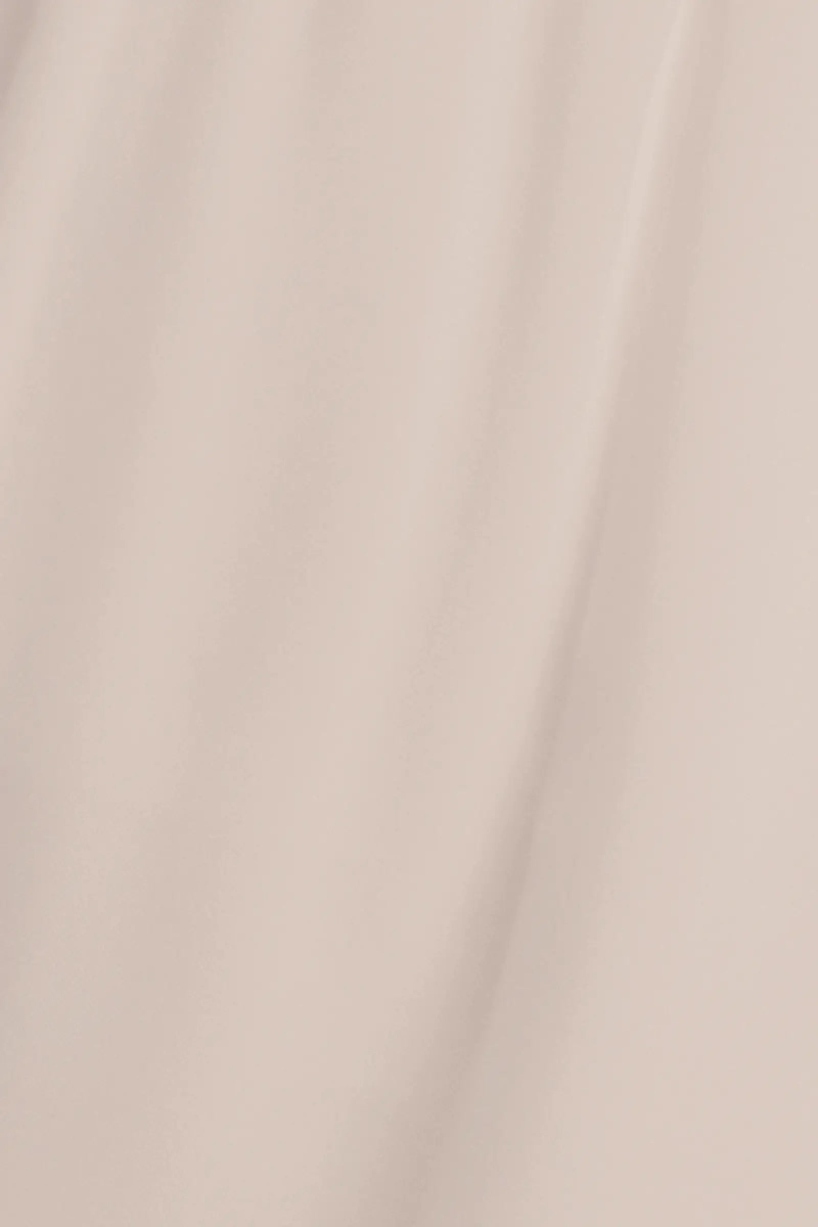 A close-up of draped satin fabric in a light champagne beige color, showing soft folds and a subtle sheen.