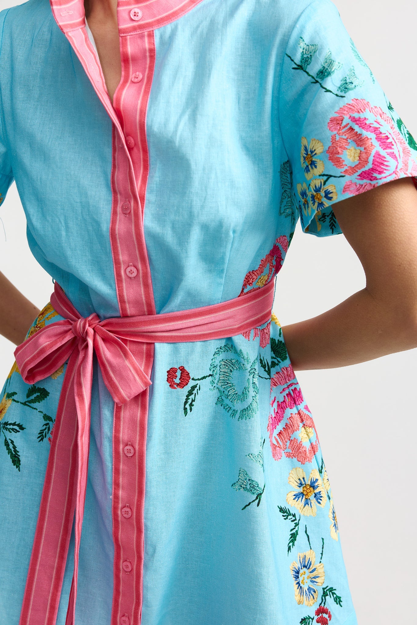 Light blue robe with floral patterns and pink accents on a plain background