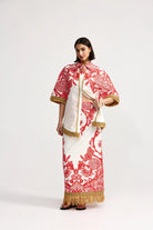 Woman wearing a red and white patterned outfit with gold accents on a white background