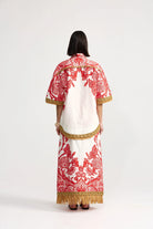 Woman wearing a traditional outfit with red and white patterns on a white background