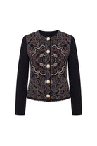 A women's cropped jacket featuring solid black long sleeves and a heavily embroidered front panel with a detailed mandala pattern in brown, beige, and red tones, accented by gold buttons.